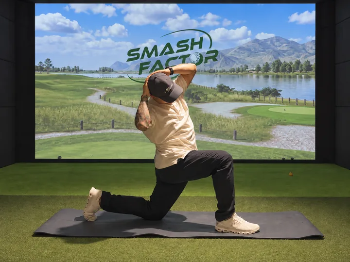 A golfer practising a half-kneeling side bend in the Smash Factor studio